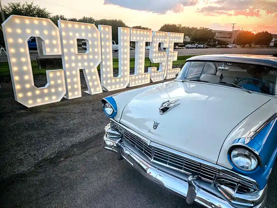 Marquee letter rental Tennessee display spelling CRUISE behind a vintage 1960s car