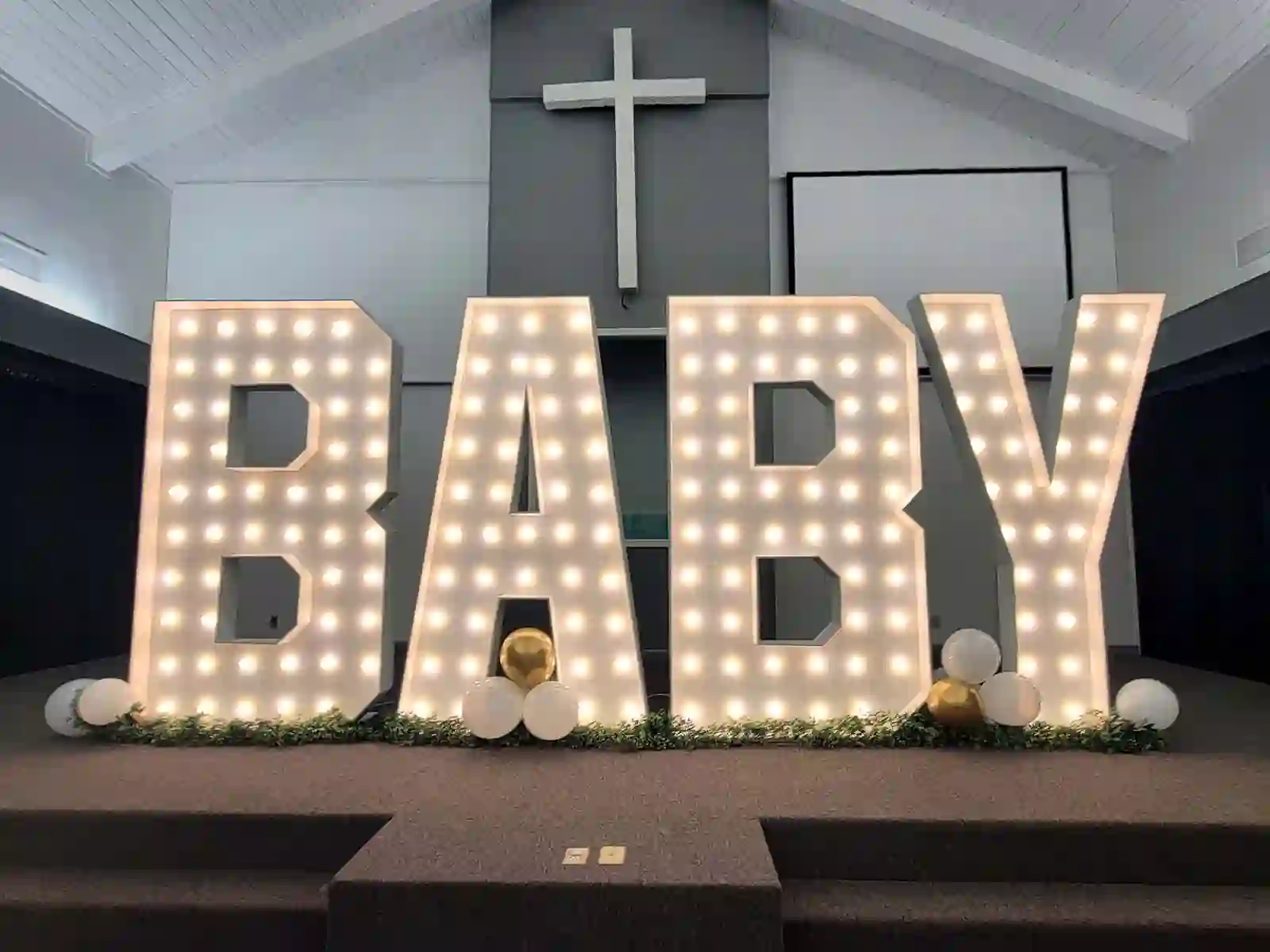 Giant 7-foot-tall baby shower marquee letters glowing at a baby shower event