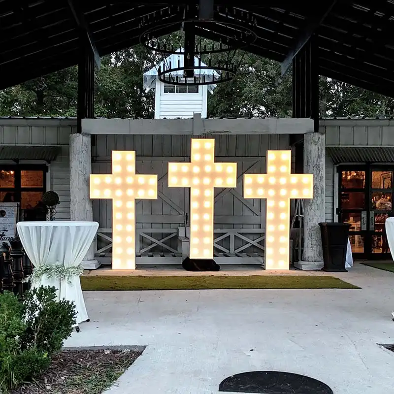 Three giant light-up marquee crosses at the entrance of a Christ-centered wedding