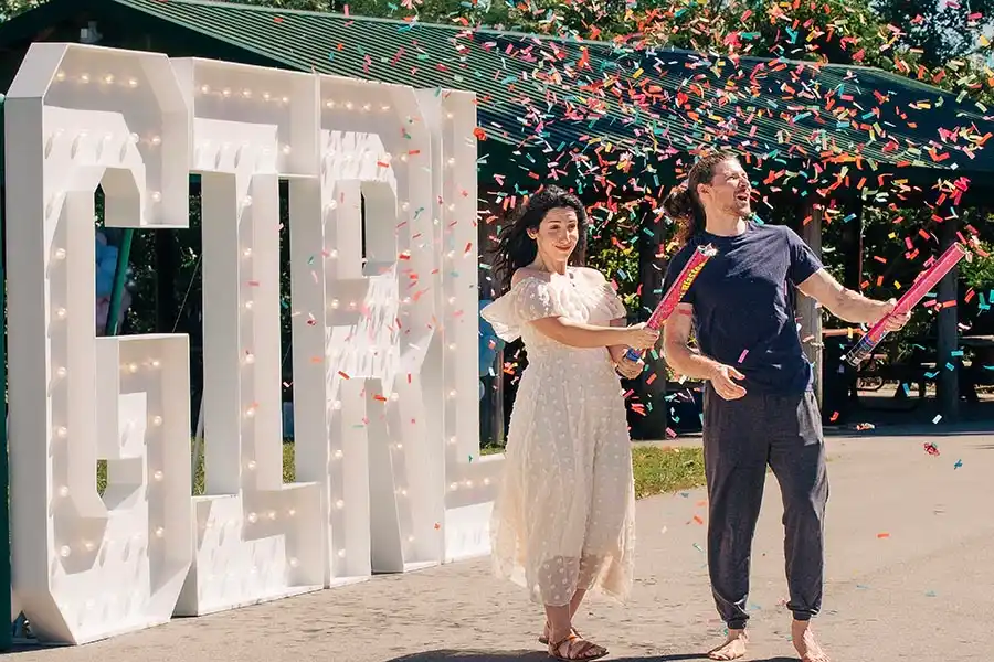 Gender reveal marquee letters in Spring Hill TN with GIRL letters, confetti, and two couples celebrating
