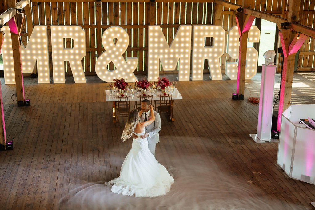 Bride and groom posing with MR & MRS marquee letters at a North Alabama wedding