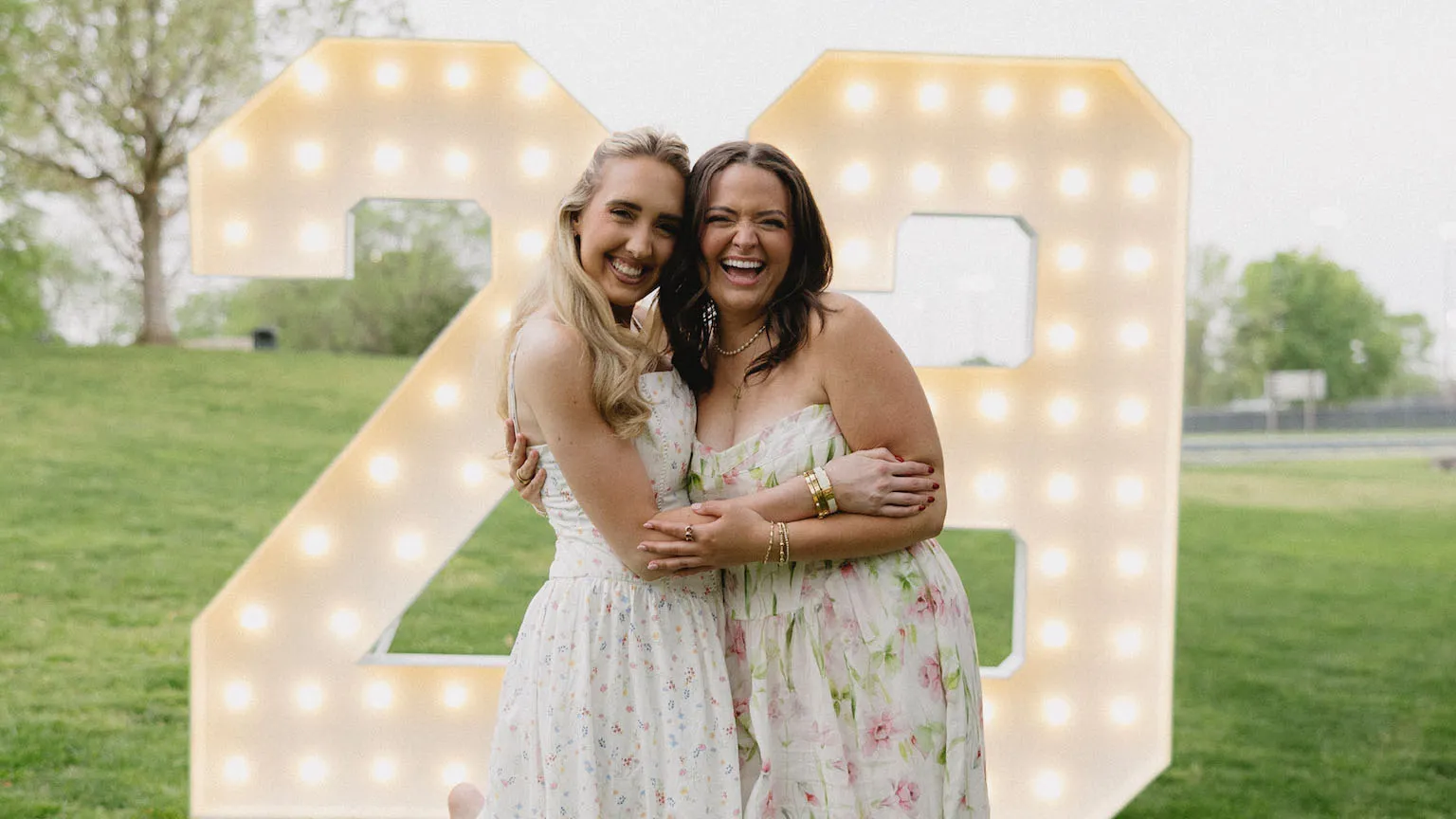 Two smiling women celebrating a 23rd birthday in Brentwood TN with giant marquee letters Brentwood in the background