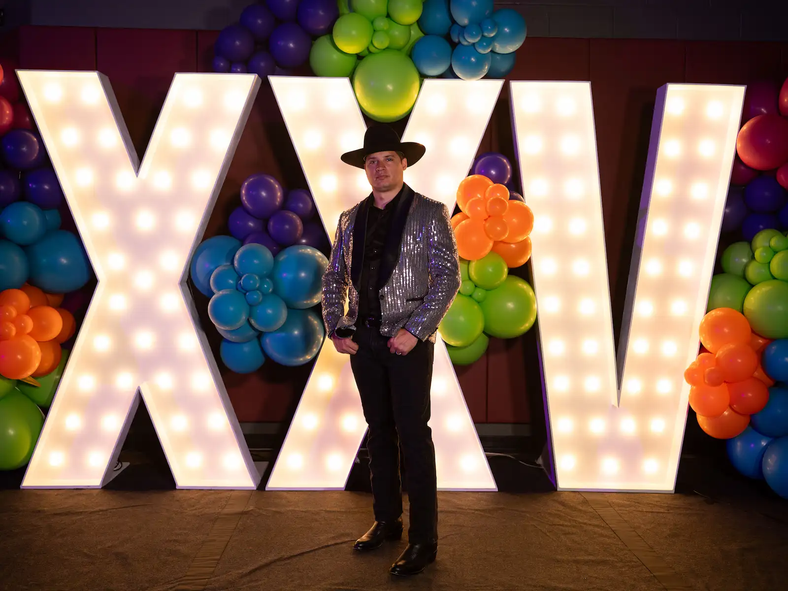 Marquee letters for prom spelling XXV with a DJ standing in front of light up letters